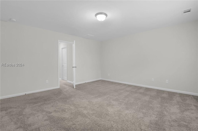 unfurnished room featuring light carpet