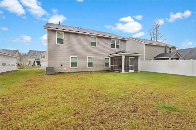 back of property with a sunroom, a yard, and central AC unit