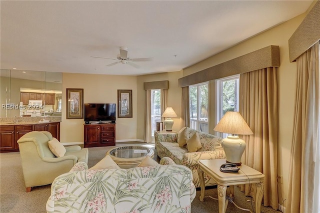 carpeted living room with ceiling fan and sink