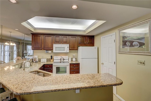 kitchen featuring pendant lighting, sink, kitchen peninsula, a raised ceiling, and white appliances