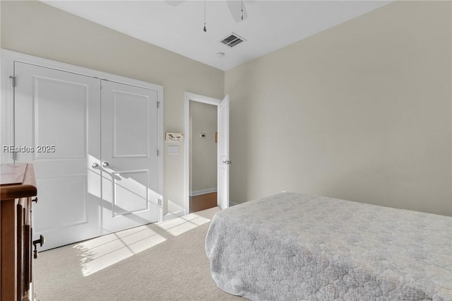 bedroom featuring light carpet, ceiling fan, and a closet