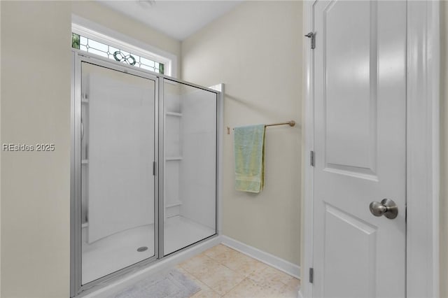 bathroom with tile patterned floors and a shower with door