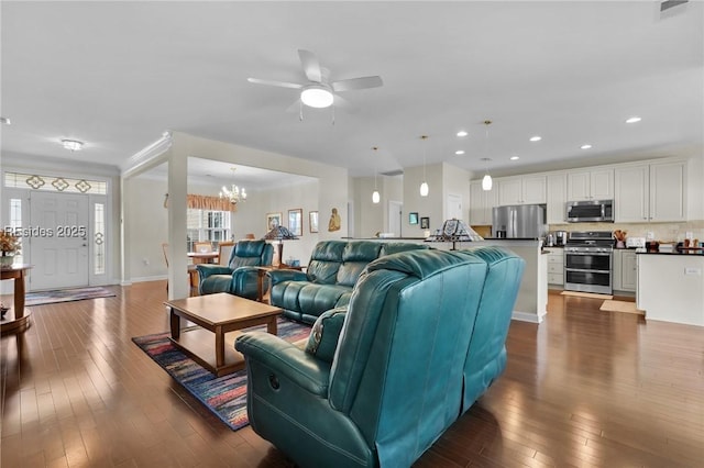 living room featuring dark hardwood / wood-style floors and ceiling fan with notable chandelier