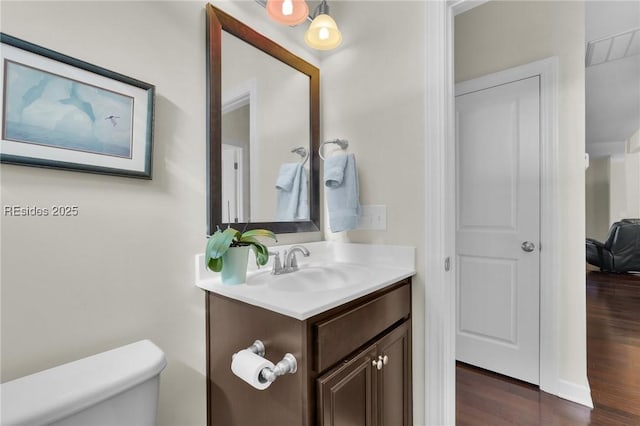 bathroom featuring vanity, toilet, and hardwood / wood-style floors