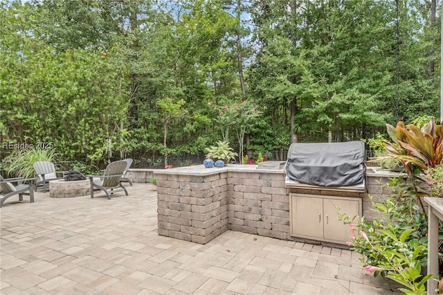 view of patio with area for grilling and a fire pit