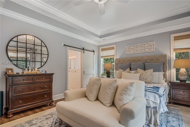 bedroom featuring ensuite bathroom, dark hardwood / wood-style floors, ornamental molding, ceiling fan, and a barn door