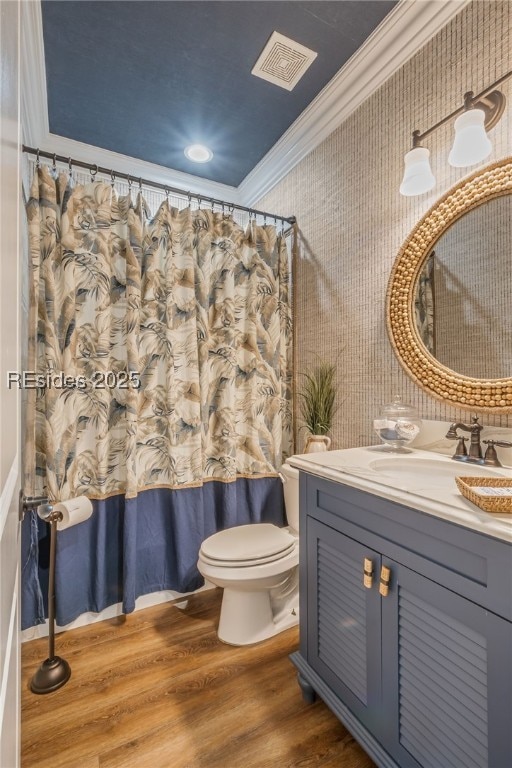 bathroom with hardwood / wood-style flooring, crown molding, vanity, and toilet