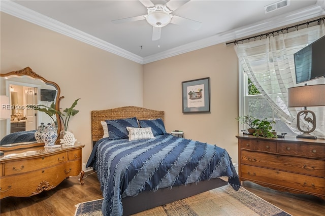 bedroom featuring crown molding, ceiling fan, hardwood / wood-style floors, and ensuite bath