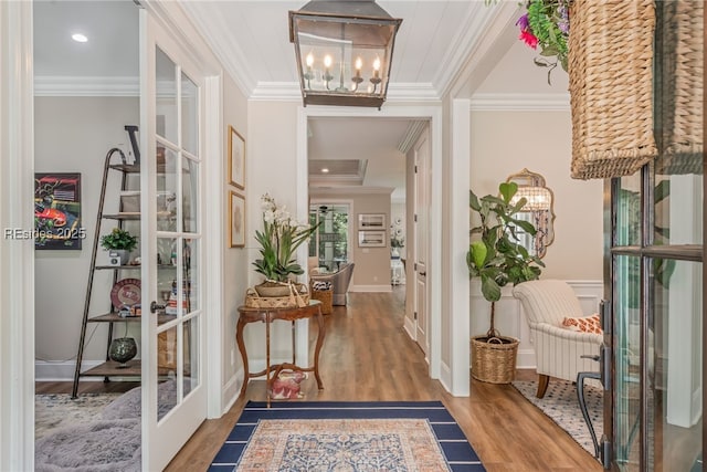 hallway with french doors, ornamental molding, and wood-type flooring