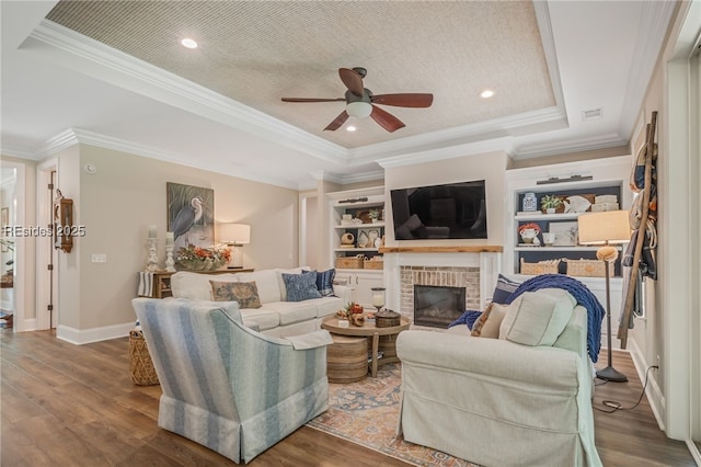 living room featuring a raised ceiling, ornamental molding, and hardwood / wood-style flooring