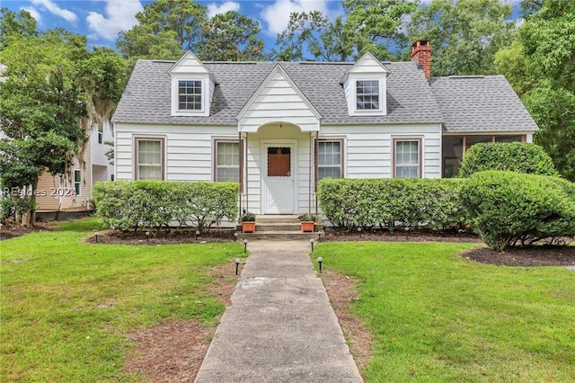 cape cod home with a front lawn