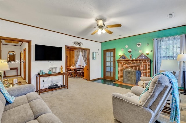 living room featuring ornamental molding, a brick fireplace, carpet floors, and ceiling fan