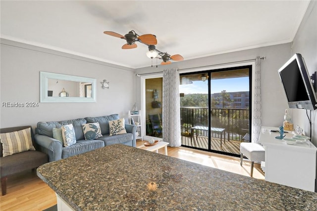 living room featuring hardwood / wood-style flooring, ornamental molding, and ceiling fan