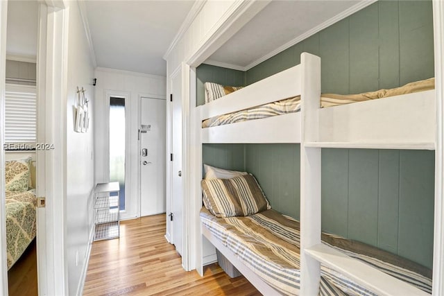 bedroom with ornamental molding and light hardwood / wood-style floors