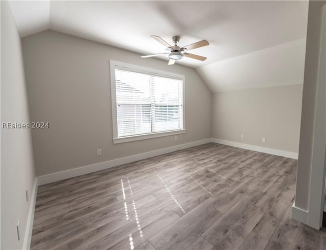 additional living space featuring hardwood / wood-style flooring, vaulted ceiling, and ceiling fan