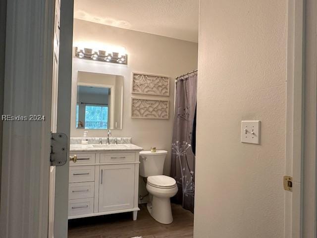 bathroom featuring hardwood / wood-style floors, vanity, toilet, a textured ceiling, and a shower with curtain