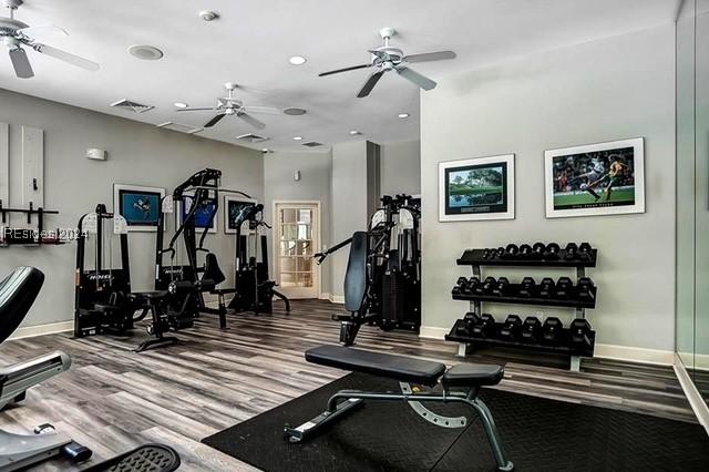 workout area featuring ceiling fan and hardwood / wood-style floors