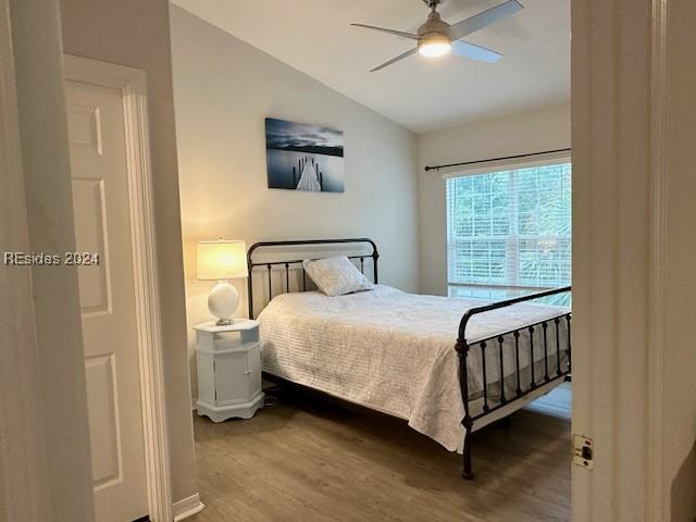 bedroom with vaulted ceiling, wood-type flooring, and ceiling fan