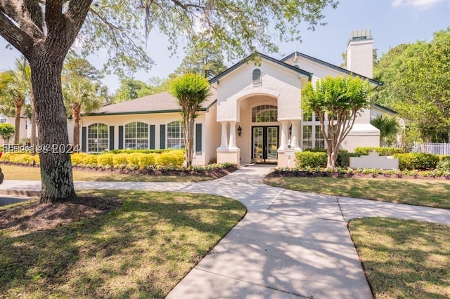 view of front of house with a front lawn and french doors