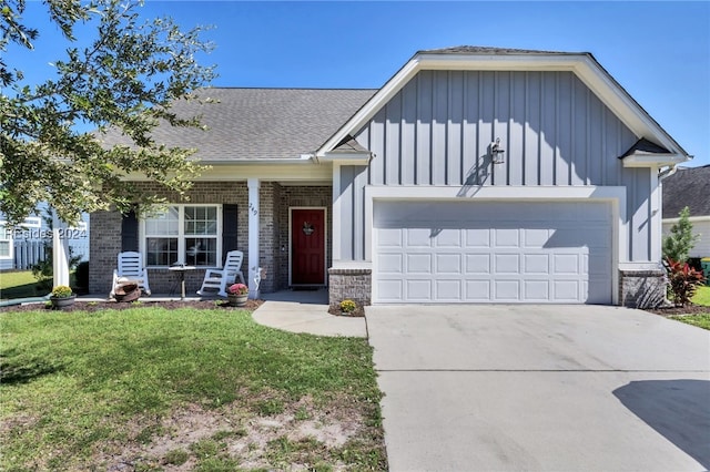 view of front of house featuring a garage, a front yard, and a porch