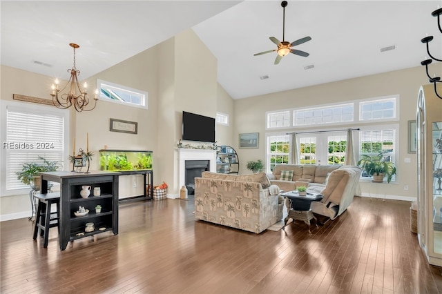 living room featuring dark hardwood / wood-style flooring, ceiling fan with notable chandelier, high vaulted ceiling, and french doors