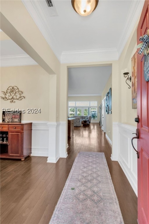 entrance foyer with dark wood-type flooring and ornamental molding