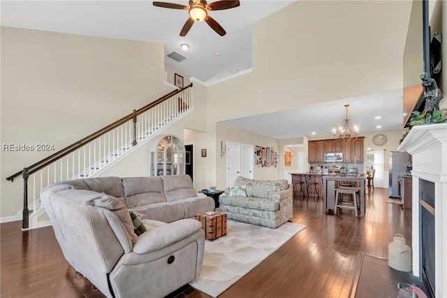 living room featuring high vaulted ceiling, ceiling fan with notable chandelier, and light wood-type flooring