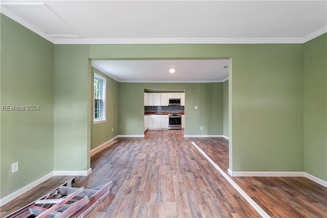 unfurnished living room featuring crown molding and hardwood / wood-style floors