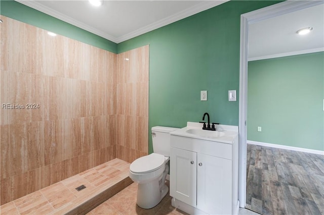 bathroom featuring vanity, a tile shower, crown molding, and toilet