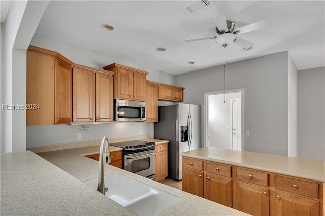 kitchen featuring pendant lighting, ceiling fan, stainless steel appliances, and sink