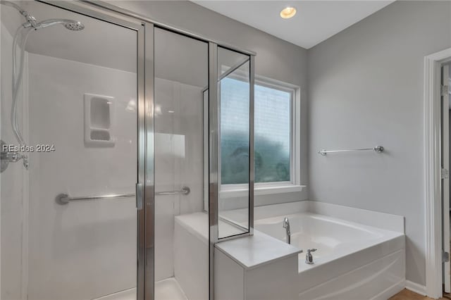 bathroom featuring plus walk in shower and a wealth of natural light