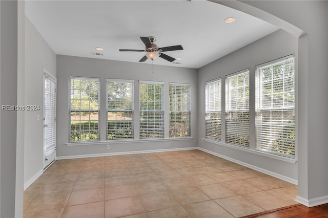 unfurnished sunroom featuring plenty of natural light and ceiling fan