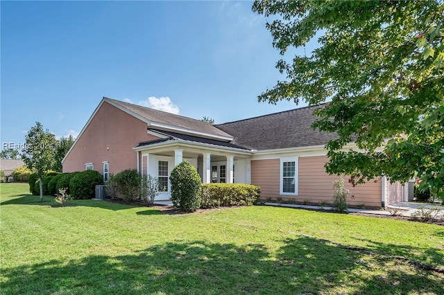 view of front of house with a front yard and central air condition unit