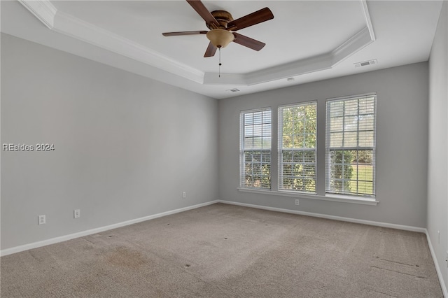 spare room with ornamental molding, carpet flooring, ceiling fan, and a tray ceiling