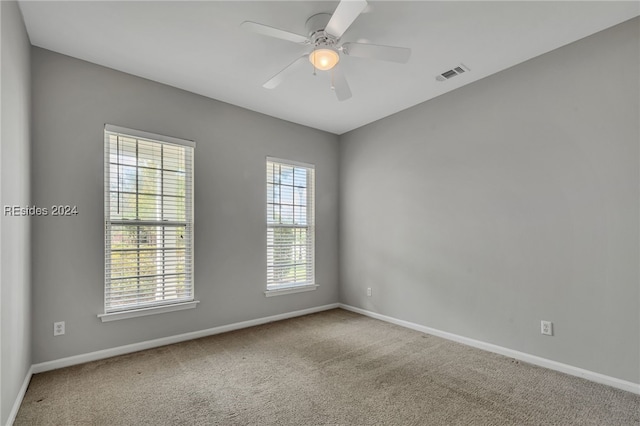 carpeted empty room featuring ceiling fan and a wealth of natural light