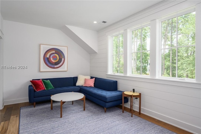 living room with hardwood / wood-style floors and wooden walls