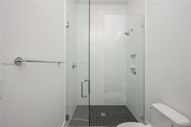 bathroom featuring an enclosed shower and toilet