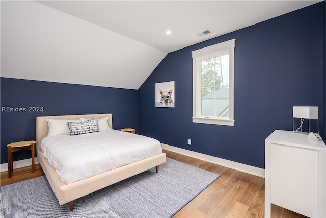 bedroom featuring hardwood / wood-style flooring and vaulted ceiling