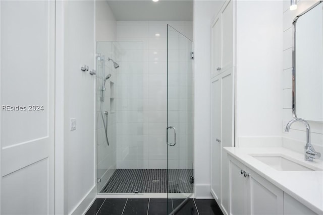 bathroom with vanity, a shower with shower door, and tile patterned floors