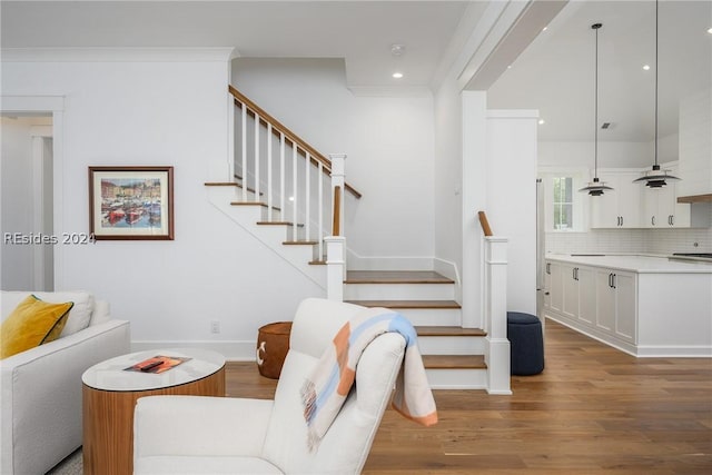 living room with crown molding and light hardwood / wood-style floors