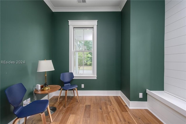 living area featuring light hardwood / wood-style flooring and ornamental molding