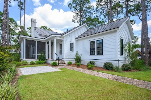 view of front of house featuring a front lawn and a sunroom