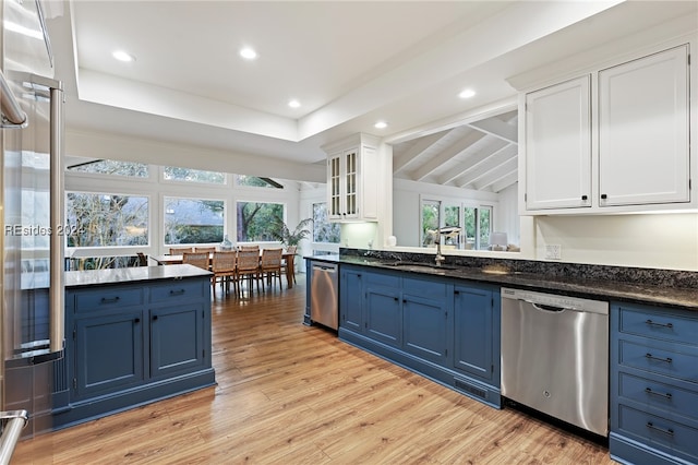 kitchen with white cabinets, blue cabinetry, and dishwasher