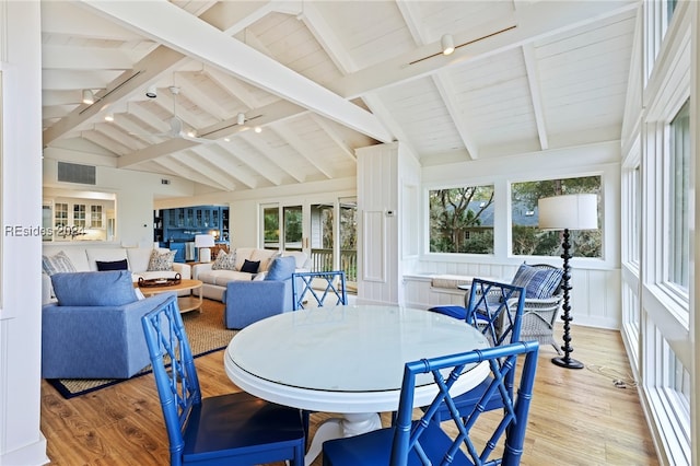 sunroom / solarium featuring vaulted ceiling with beams