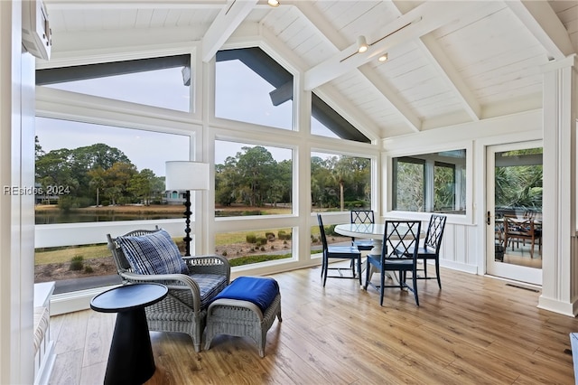 sunroom featuring vaulted ceiling with beams and a water view