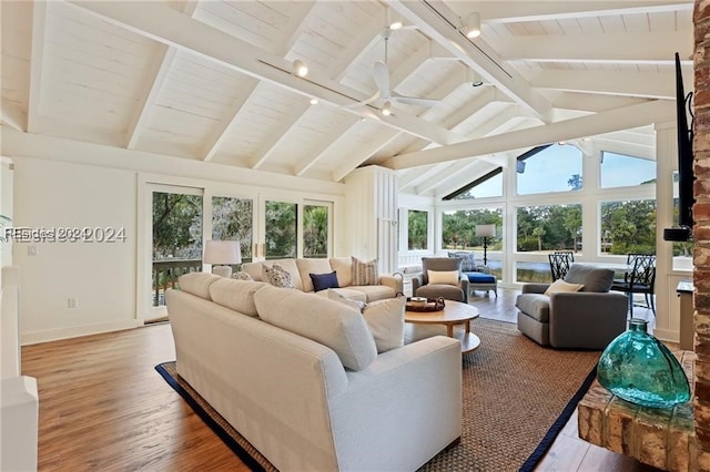 living room featuring hardwood / wood-style floors, track lighting, vaulted ceiling with beams, and ceiling fan