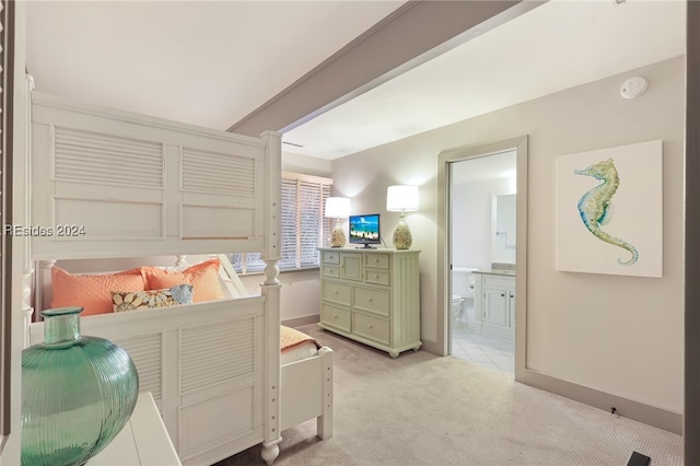 bedroom featuring light colored carpet and connected bathroom