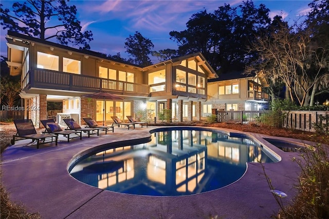 pool at dusk featuring a patio