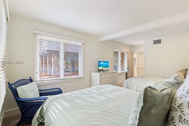 bedroom featuring multiple windows and beamed ceiling