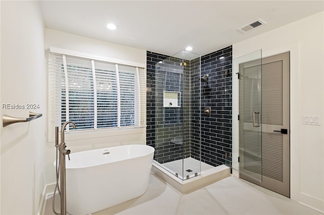 bathroom featuring independent shower and bath and tile patterned flooring